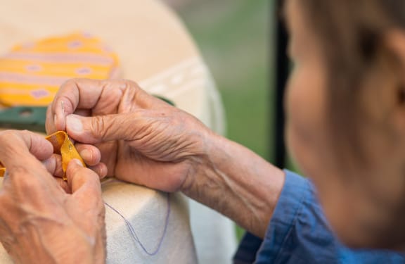 Close up of a womans hands sewing a piece of fabric