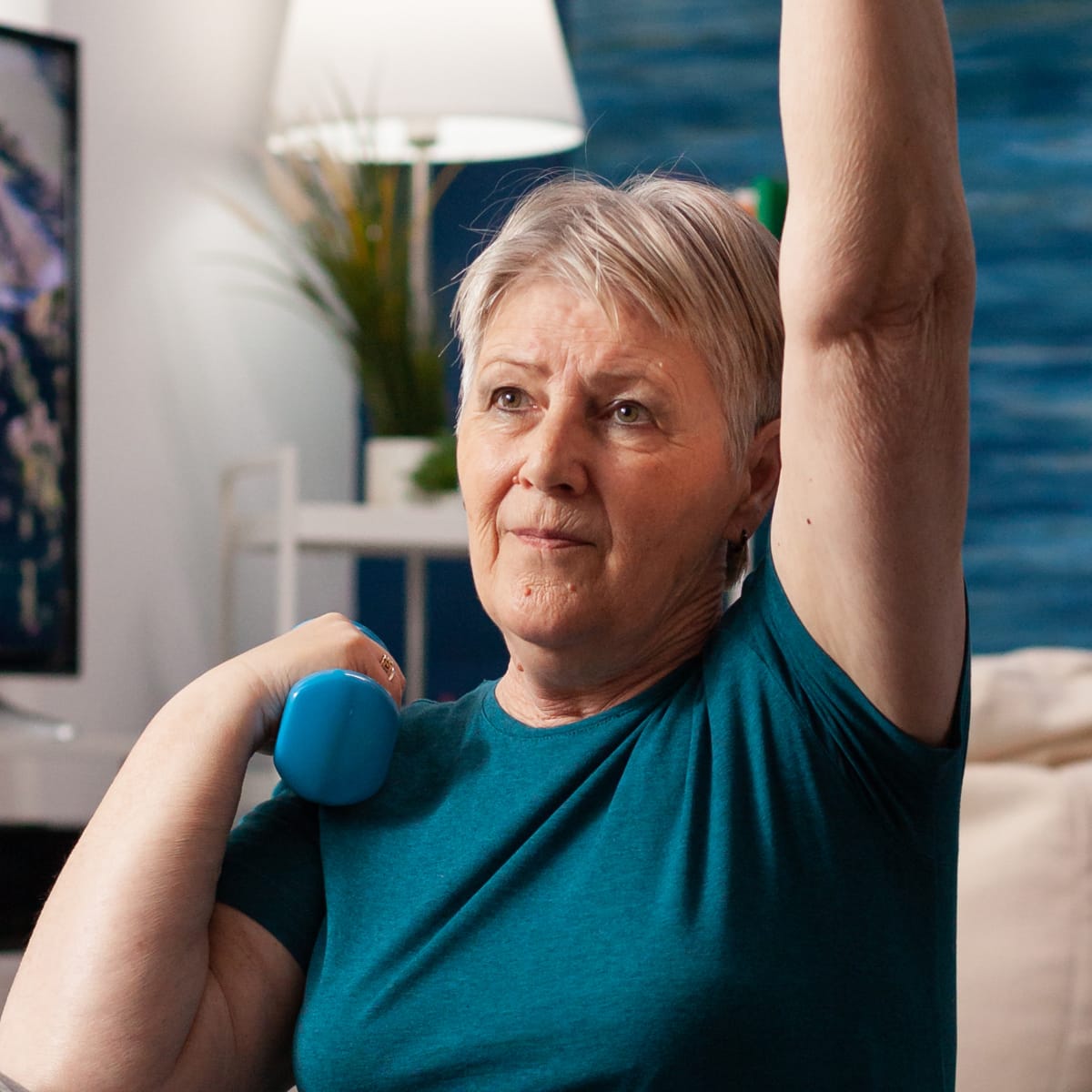 Elderly woman doing arm excercises with small weights