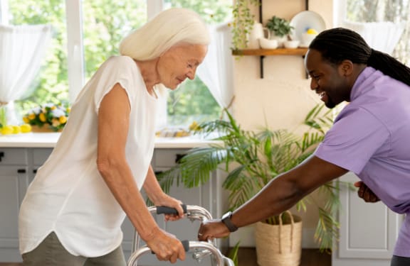 Care giver helping an older woman with her walker